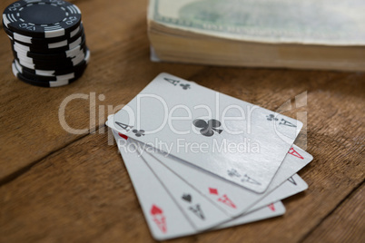 Close-up of four aces by chips and money