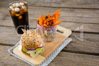 French fries by burger on cutting board with drink