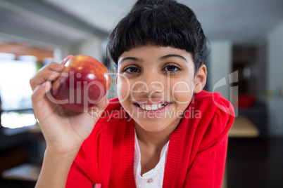 Close-up portrait of smiling girl with fresh apple