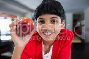 Close-up portrait of smiling girl with fresh apple