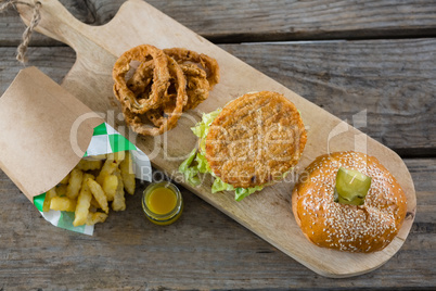 Overhead view of burger with onion rings and french fries