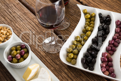 Close-up of marinated olives with glasses of wine