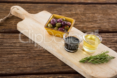 Marinated olive, rosemary with olive oil and balsamic vinegar on table