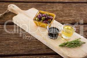 Marinated olive, rosemary with olive oil and balsamic vinegar on table