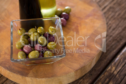 Marinated olives with olive oil and balsamic vinegar bottles on table