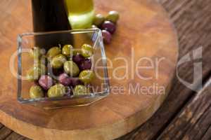 Marinated olives with olive oil and balsamic vinegar bottles on table