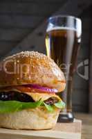 Burger with glass of beer on chopping board