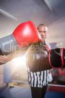 Close-up of boxers punching fists against referee