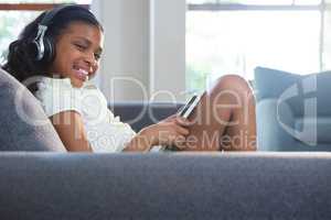Portrait of girl listening music while using tablet computer