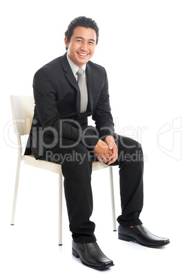 Full body Asian businessman sitting on white chair