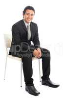 Full body Asian businessman sitting on white chair