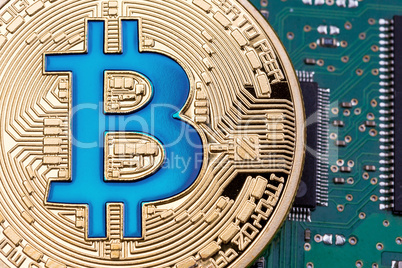 Golden Bitcoin currency on a circuit board background.
