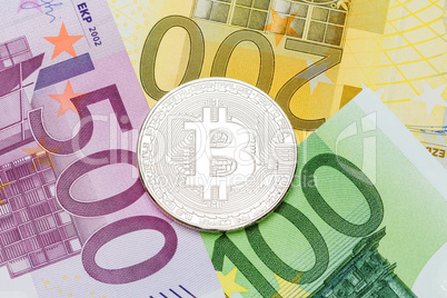 Silver Bitcoin close-up. Euro currency as a background. Macro ph