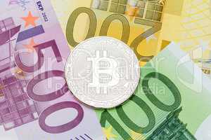 Silver Bitcoin close-up. Euro currency as a background. Macro ph
