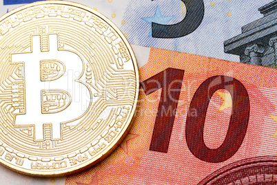 Ten euro banknote as a background for golden bitcoin.