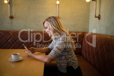 Beautiful woman using mobile phone at table