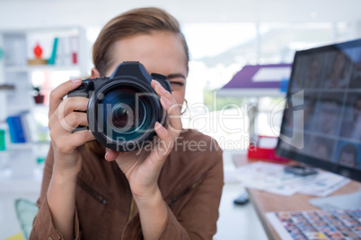 Female executive taking a photograph from digital camera