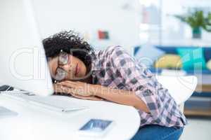 Female executive sleeping at desk