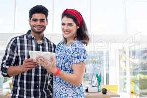 Couple using digital tablet in the office