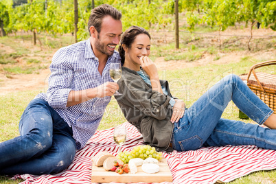 Smiling man with woman having wine at lawn