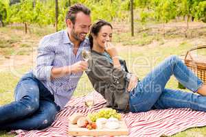 Smiling man with woman having wine at lawn