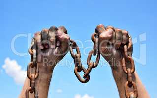 Two male hands holding a rusty metal chain