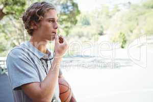 Man with basketball whistling