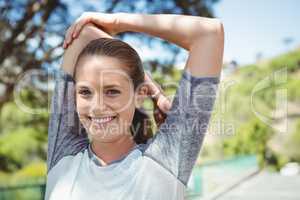 Portrait of smiling woman practicing stretching exercise