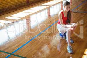 Young woman using mobile phone in basketball court