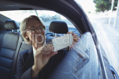 Businesswoman photographing in car