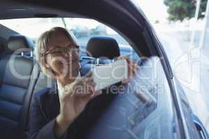 Businesswoman photographing in car