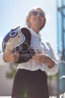 Businesswoman holding helmet on sunny day