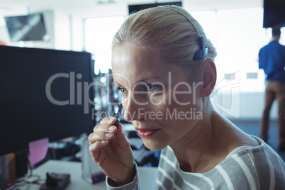 Thoughtful businesswoman wearing headphones