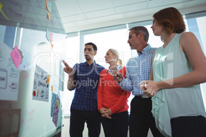 Low angle view of business entrepreneurs discussing over whiteboard at office