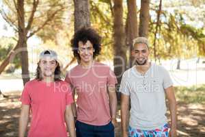 Portrait of smiling male friends at forest