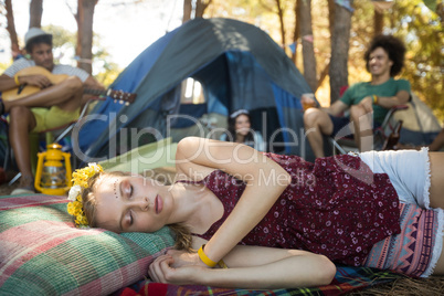 Woman sleeping while friends sitting in background