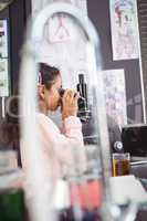 Side view of elementary student looking through microscope at laboratory