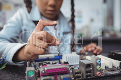 Mid section of elementary girl assembling circuit board