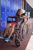 Portrait of student sitting on wheelchair in corridor