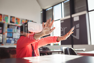 Schoolgirl gesturing while using virtual reality glasses