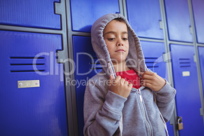 Boy wearing hooded shirt by lockers