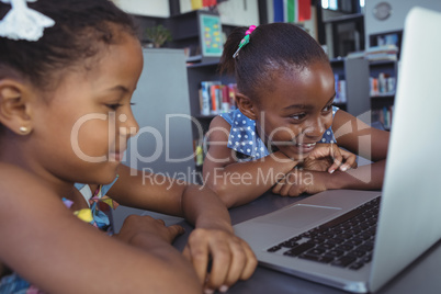 Girls looking in laptop at desk