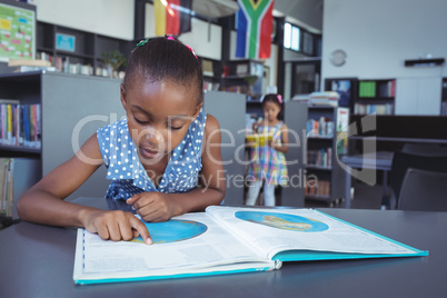 Girl reading book in library