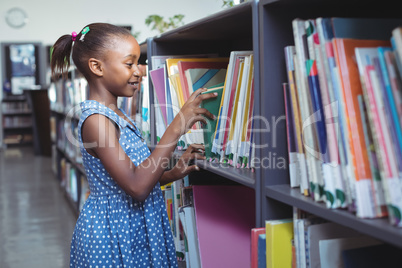 Girl choosing book in library