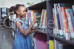Girl choosing book in library