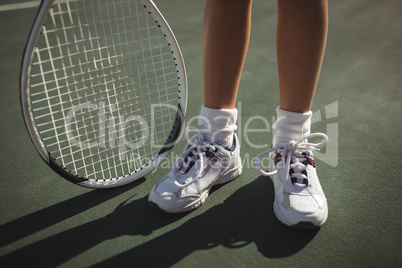 Low section of girl with tennis racket