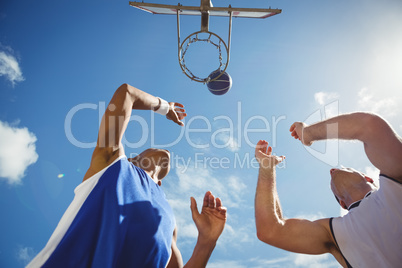 Low angle view of friends playing basketball