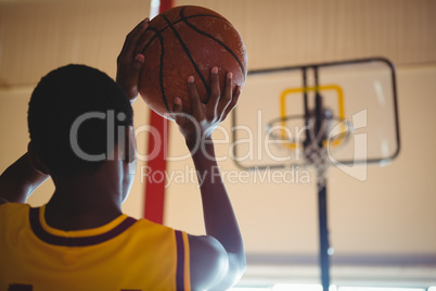 Rear view of teenage boy playing basketball