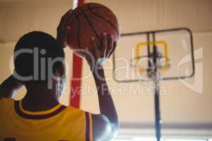 Rear view of teenage boy playing basketball