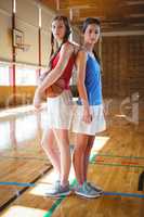 Portrait of female basketball players standing back to back
